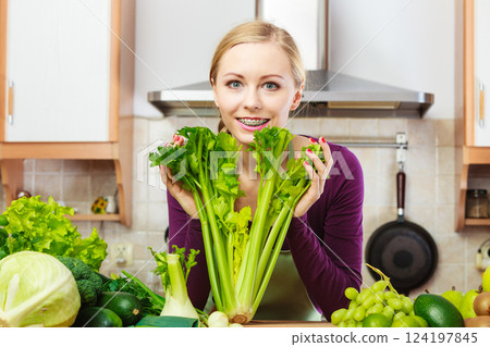 Woman in kitchen with green vegetables Woman in kitchen with green vegetables 124197845