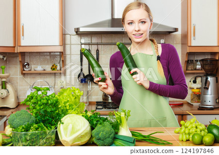 Woman housewife in kitchen with green vegetables Woman housewife in kitchen with green vegetables 124197846