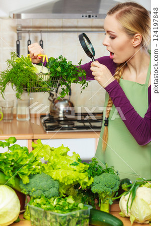 Woman looking through magnifier at vegetables basket 124197848