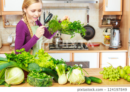 Woman looking through magnifier at vegetables basket 124197849