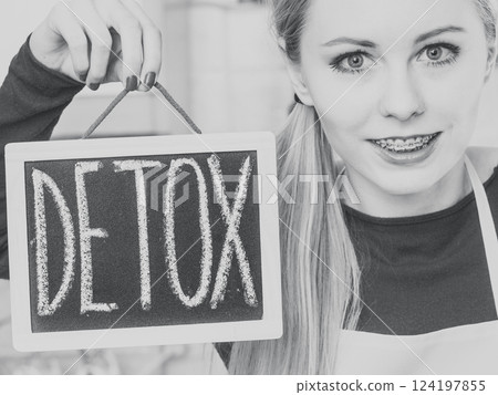 Happy woman holding board with detox sign 124197855