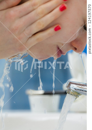 Woman washing face in bathroom. Hygiene. Woman washing face in bathroom. Hygiene. 124197870