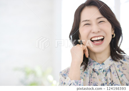 一位身穿花襯衫、微笑的中年婦女 一位身穿花襯衫、微笑的中年婦女 124198393