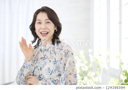 A smiling middle-aged woman wearing a floral blouse A smiling middle-aged woman wearing a floral blouse 124198394
