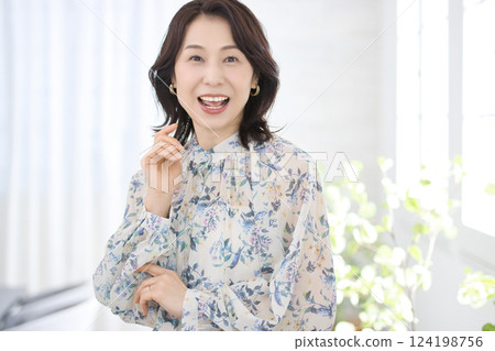 一位身穿花襯衫、微笑的中年婦女 一位身穿花襯衫、微笑的中年婦女 124198756