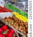 Various type of fresh fruits arrange neatly, grocery store. Radishes, tomatoes, yellow peppers, green vegetables on rack.  124199203
