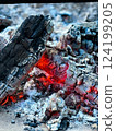 A close up of burning embers and ashes in the fire. 124199205