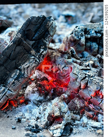 A close up of burning embers and ashes in the fire. A close up of burning embers and ashes in the fire. 124199205