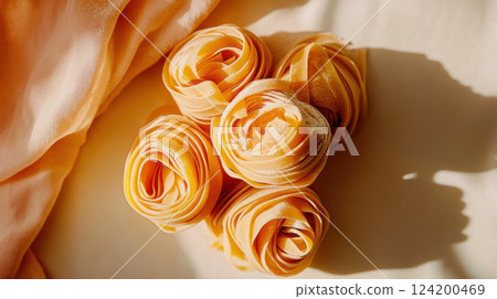 Close-up of handmade tagliatelle pasta nests dusted with flour. Rustic, traditional Italian cooking ingredients displayed in warm natural light 124200469