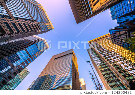 日本東京城市景觀：大手町和丸之內辦公大樓在落日的餘暉中沐浴著橘色光芒 124200481