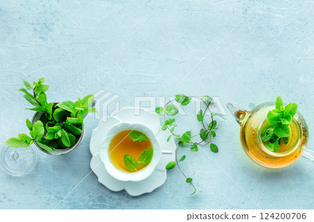 Mint tea. A cup of peppermint tea with fresh mint leaves and a tea pot 124200706