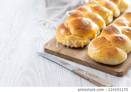 Traditional Easter braided bread. Tsoureki braid on white wooden table 124201170