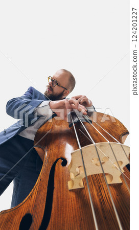 Bearded man in suit playing double bass fully immersed in rhythm and sound against white background. 124201227
