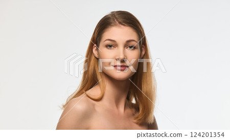Charming woman with radiant skin and delicate smile, natural makeup, smooth hair cascading over shoulder, looking into camera Charming woman with radiant skin and delicate smile, natural makeup, smooth hair cascading over shoulder, looking into camera 124201354