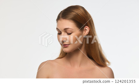 Attractive young woman with perfect skin tilting head slightly downward, soft lighting emphasizing contours of face isolated on white background. 124201355