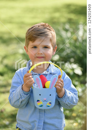 A boy looking for eggs in a bag for Easter 124201409