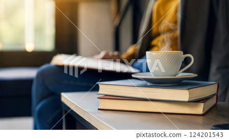 Cozy reading corner with books and coffee cup in warm sunlight atmosphere 124201543