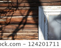 Corner of white window on wooden brown wall 124201711