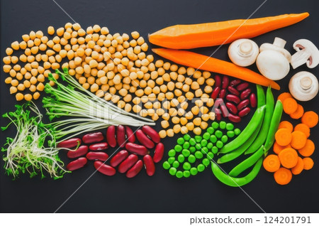 Dark Delicious Vegan Meal Top Down Image Of Fresh, Colorful, Green Vegetarian Feast With Chickpeas, Carrots, And Peas On Matte Surface Dark Delicious Vegan Meal Top Down Image Of Fresh, Colorful, Green Vegetarian Feast With Chickpeas, Carrots, And Peas On Matte Surface 124201791