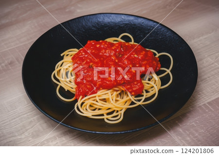 Delectable Single Serving Of Pasta With Tomato Sauce Black Plate Dish On Wood Tabletop, Capturing Top-Down View Of Classic Cuisines Rich Flavors And Textures 124201806