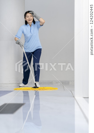 Image of building cleaning: Middle-aged female cleaning staff mopping the floor 124202445