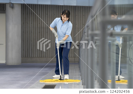 Image of building cleaning: Middle-aged female cleaning staff mopping the floor 124202456