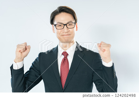 一位商人一邊看著鏡頭，一邊舉起拳頭擺姿勢 124202498