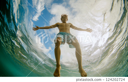 Young man jumping into water. Beach feeling. Shot from below through fish-eye. Immersive POV. 124202724