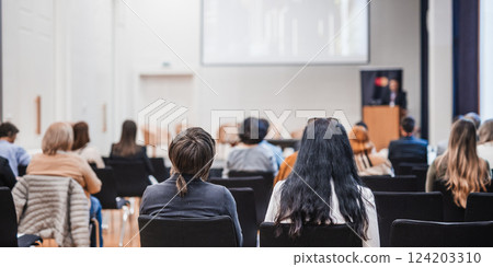 Speaker giving a talk in conference hall at business event. Rear view of unrecognizable people in audience at the conference hall. Business and entrepreneurship concept Speaker giving a talk in conference hall at business event. Rear view of unrecognizable people in audience at the conference hall. Business and entrepreneurship concept 124203310