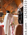 View of the wedding from the back. The priest conducts the ceremony. 124203419