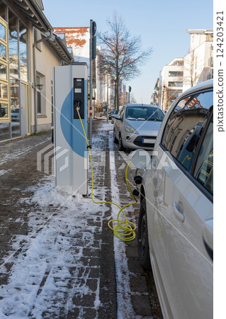 An electric car on the street is being charged in Germany. 124203421