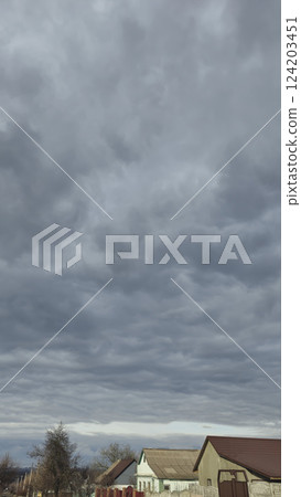 Blue sky with clouds, winter weather. Clouds on the background of trees. 124203451