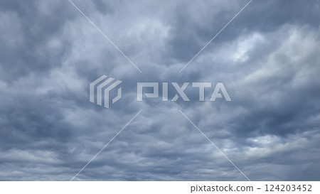 Blue sky with clouds, winter weather. Clouds on the background of trees. Blue sky with clouds, winter weather. Clouds on the background of trees. 124203452
