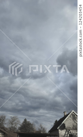 Blue sky with clouds, winter weather. Clouds on the background of trees. Blue sky with clouds, winter weather. Clouds on the background of trees. 124203454