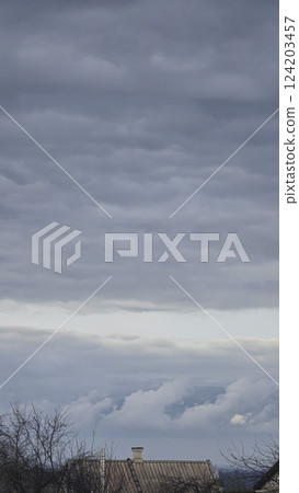 Blue sky with clouds, winter weather. Clouds on the background of trees. Blue sky with clouds, winter weather. Clouds on the background of trees. 124203457