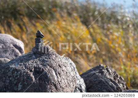 Stacked stones resting on a rock Stacked stones resting on a rock 124203869