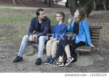 Family talking and discussing issues while sitting on bench in park Family talking and discussing issues while sitting on bench in park 124205120