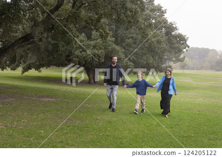 Happy family walking in the park on a cloudy day Happy family walking in the park on a cloudy day 124205122