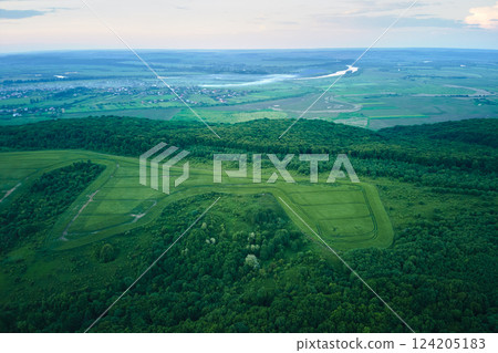 Aerial landscape of green farmland in summer season with growing crops. Agricultural cultivated field. Farming and agriculture industry 124205183