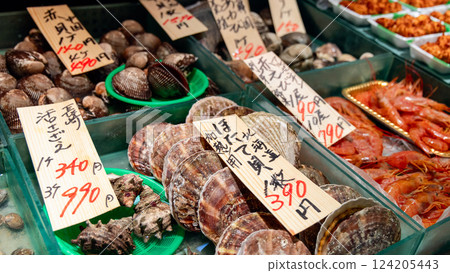 A seafood display at a Tokyo fish market featuring fresh scallops, clams, shrimp, and shellfish A seafood display at a Tokyo fish market featuring fresh scallops, clams, shrimp, and shellfish 124205443