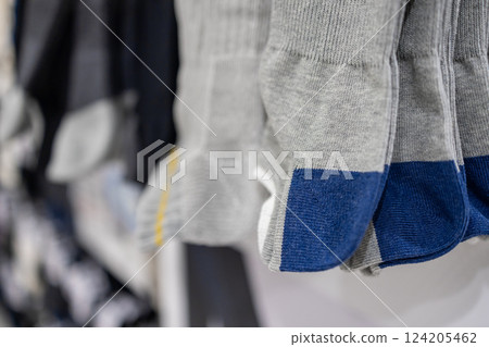 Gray and blue socks with reinforced toe and heel sections neatly displayed on a store rack Gray and blue socks with reinforced toe and heel sections neatly displayed on a store rack 124205462