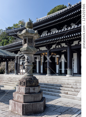 Ornate stone lantern with Japanese inscriptions stands before the entrance of Hasedera temple 124205466