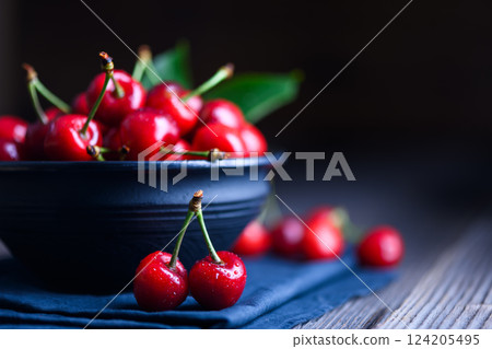 Bowl with just washed red cherries on wooden table Bowl with just washed red cherries on wooden table 124205495