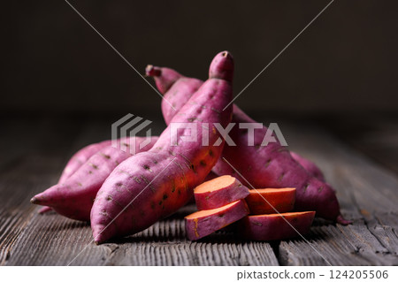 Heap of pink organic raw sweet potatoes on wooden rustic table Heap of pink organic raw sweet potatoes on wooden rustic table 124205506