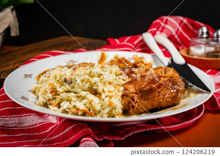 Braised pork in a spicy sauce served with bulgur and sauerkraut salad. 124206219