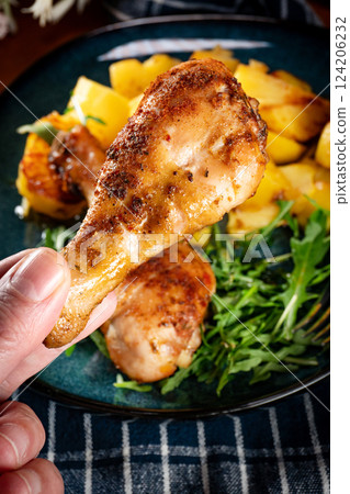 Baked chicken drumsticks with potatoes. 124206232