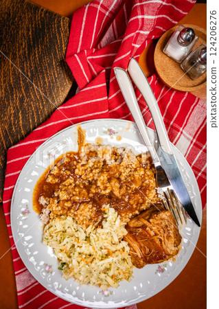 Braised pork in a spicy sauce served with bulgur and sauerkraut salad. Braised pork in a spicy sauce served with bulgur and sauerkraut salad. 124206276