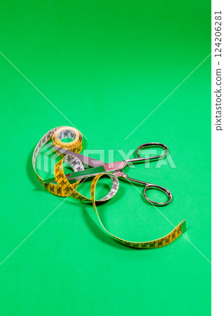 Tape measure and sharp tailor's scissors, placed on the table. 124206281