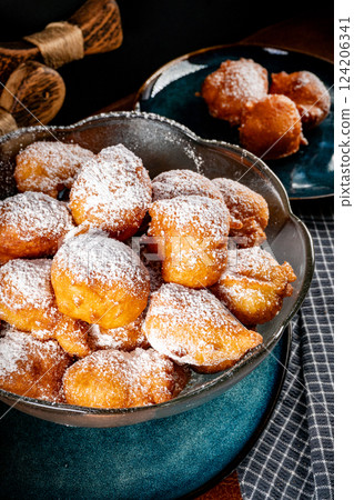 Small doughnuts with powdered sugar. Small doughnuts with powdered sugar. 124206341