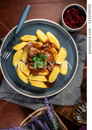 Beef stew in gravy served with potato dumplings. 124206608